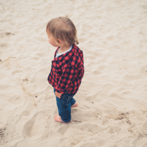 little boy walking on sand